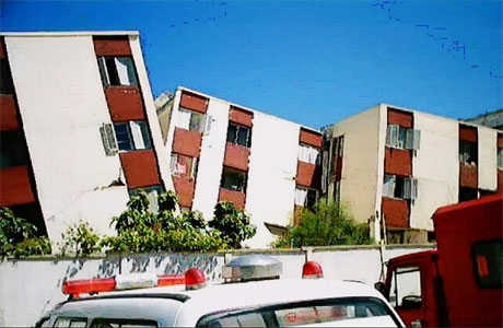 . ميلان مبانٍ سكنية على بعضها البعض في مدينة بومرداس (شرق الجزائر العاصمة) بفعل اهتزاز الأرض المرافق للزلزال الذي وقع بتاريخ 21/5/2003. [مصدر الصورة: اللعوامي، 2003].
