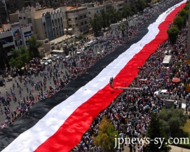 مئات الآلاف يرفعون أكبر علم سوري بطول 2300 متر في دمشق